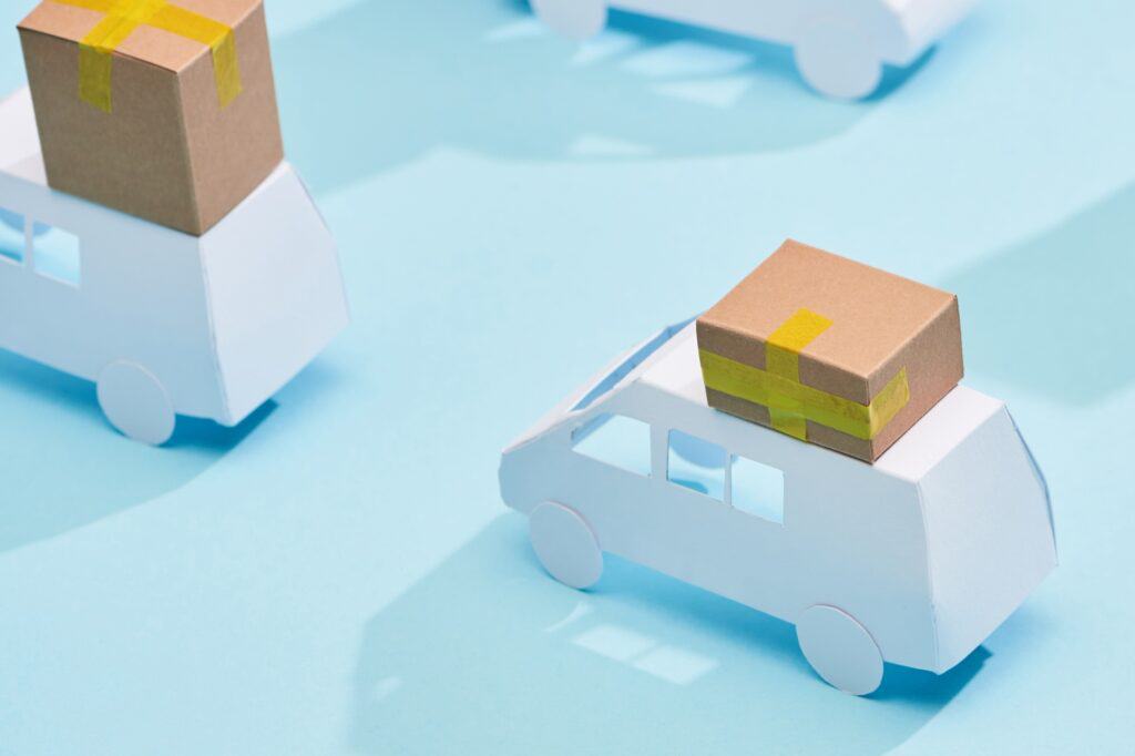 Cropped image of miniature vans carrying cartons in the concept of 'How to Choose the Best Home Removals Company'.