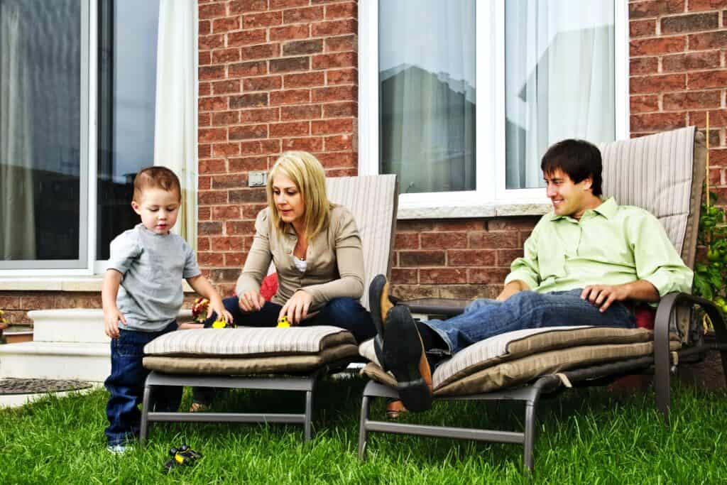 A small, young family relaxing at their garden after settling in their new home